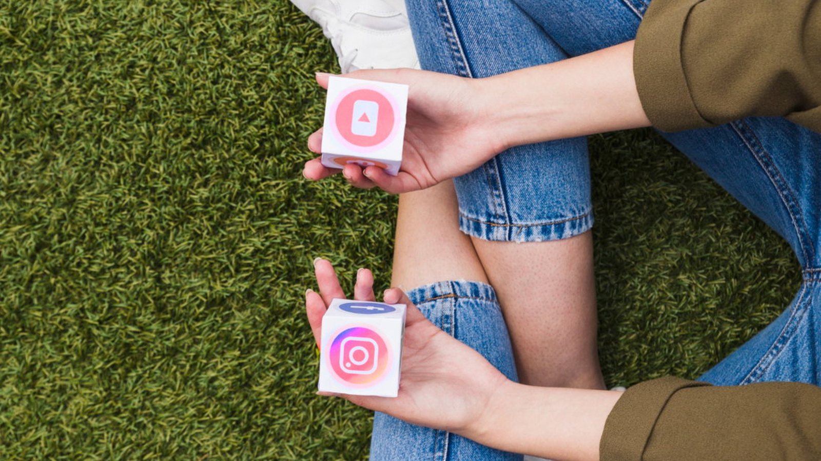 Mãos segurando dois cubos de papel com os ícones do Instagram e de redes sociais
