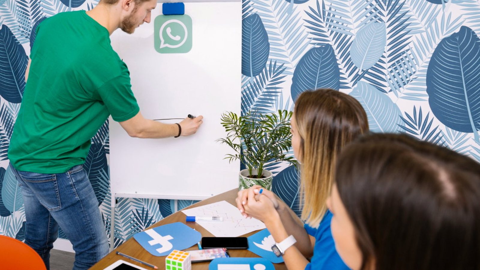 Equipe reunida diante de um quadro branco com o ícone do WhatsApp